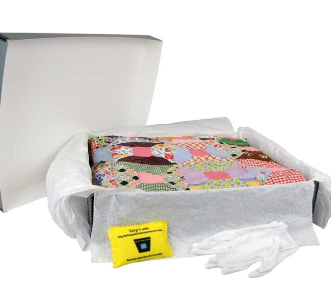 Archival textile storage kit with gloves, desiccant, unbuffered tissue, and a crazy quilt stored inside.