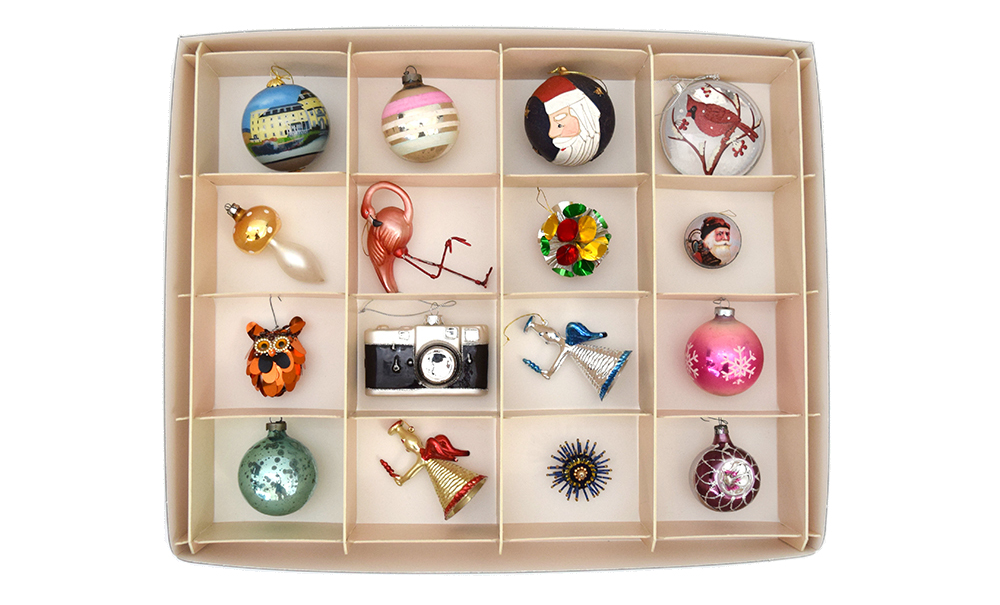 Overhead view of Archival Methods tan divided storage box with 16 compartments filled with glass Christmas ornaments.