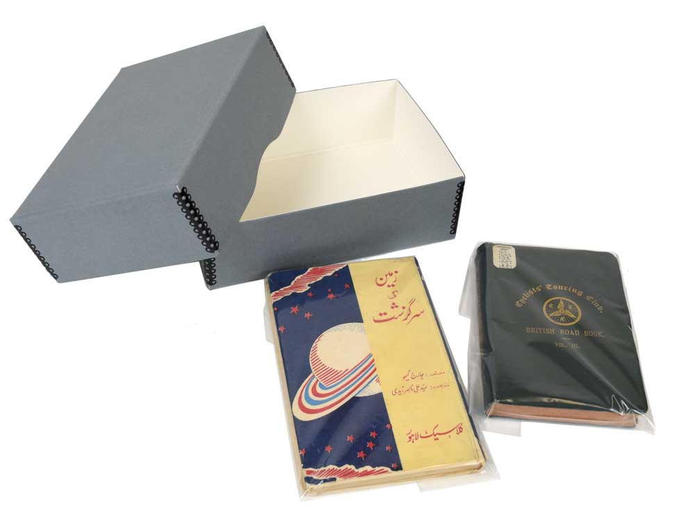 Two vintage books inside polyethylene bags next to an archival metal edge box