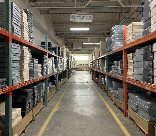 warehouse aisle view featuring tan, black, and gray archival metal edge boxes at Archival Methods
