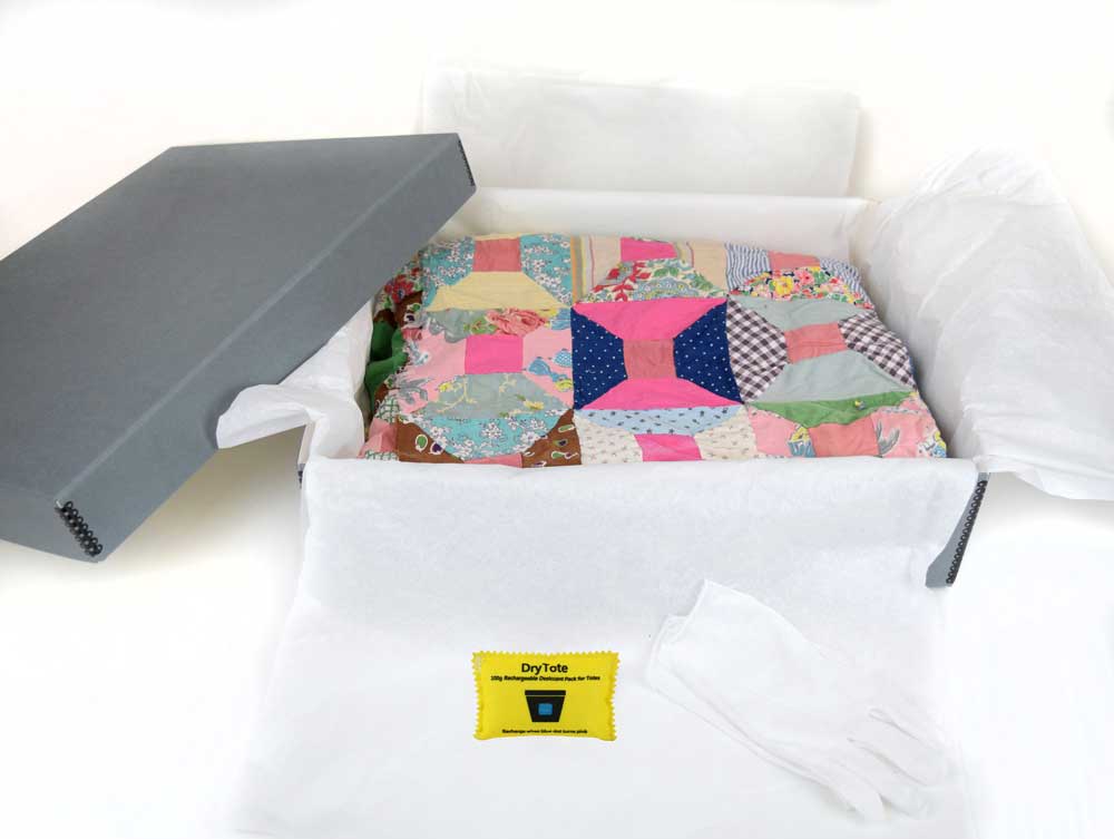 Textile Storage Kit with an acid-free box, tissue paper, cotton gloves, and desiccant for preserving quilts and delicate fabrics.