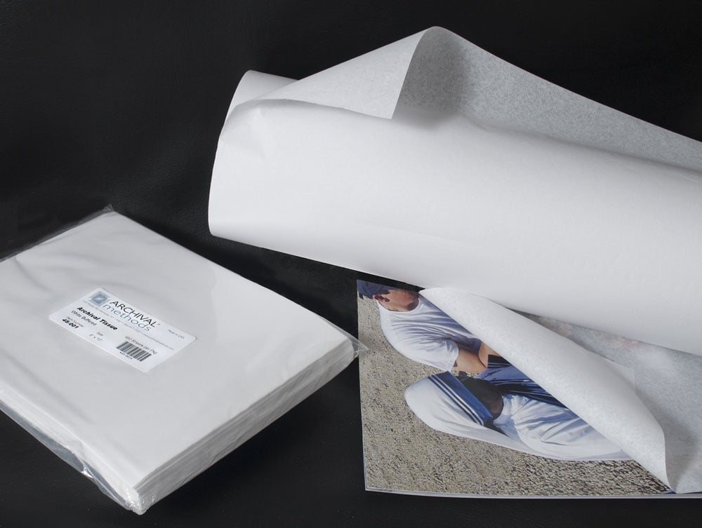 Buffered and unbuffered archival tissue in sheets and rolls used as interleaving for a photograph, showcasing its acid-free transparency for protecting photos and art. 
