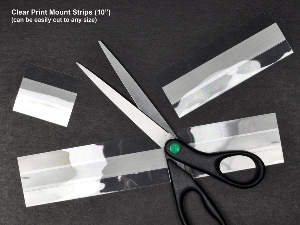 Archival-quality clear print mounting strips with self-adhesive backing, securely holding artwork in place without direct contact with adhesive. 