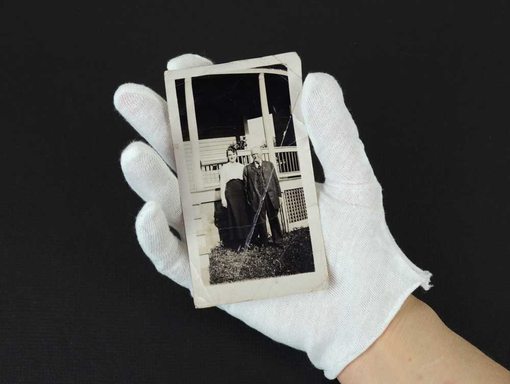 White cotton inspection gloves protect photographs and artifacts from oils and fingerprints during handling and archival care. 