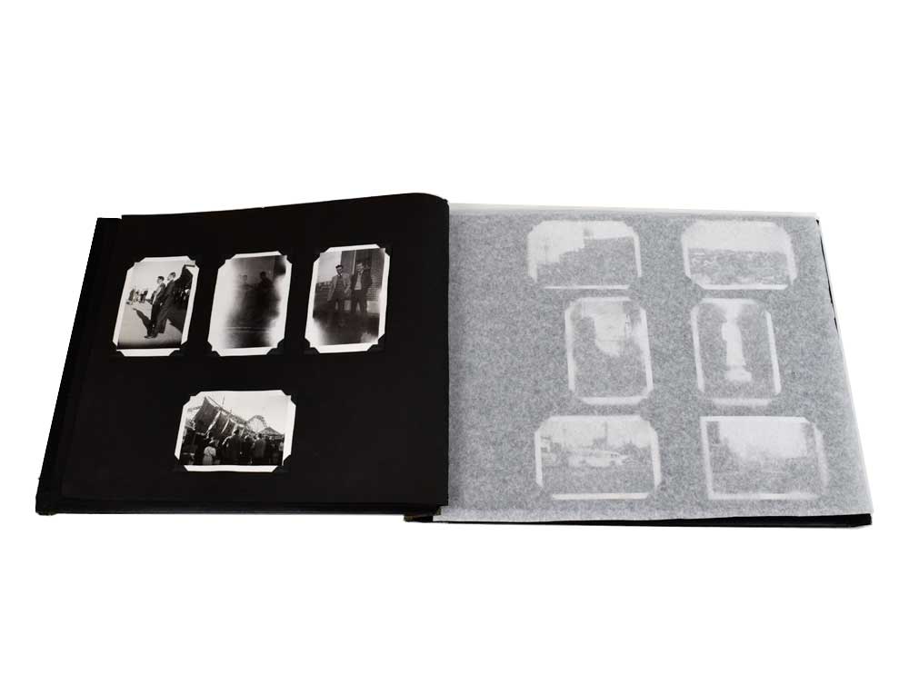 Archival tissue used as interleaving for a vintage photo album, showcasing its acid-free thinness and transparency for protecting photos. 