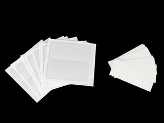 Transparent adhesive vinyl label holders securely attached to a storage box, ensuring easy organization and clear identification of contents
